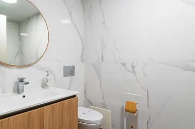 a white bathroom with a sink and a mirror at GuestReady - The perfect view in Funchal in Funchal