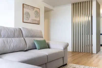 a living room with a gray couch with a green pillow at GuestReady - The perfect view in Funchal in Funchal