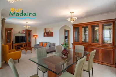a dining room and living room with a table and chairs at OurMadeira - Yellow House in Raposeira do Logarinho