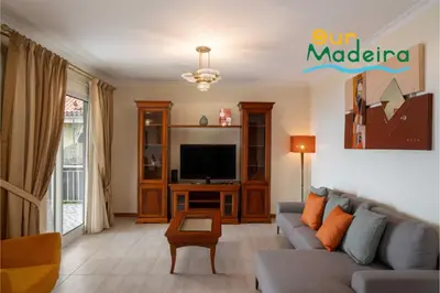 a living room with a couch and a tv at OurMadeira - Yellow House in Raposeira do Logarinho