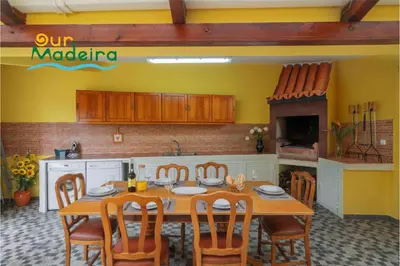 a kitchen with a table and chairs in a kitchen at OurMadeira - Yellow House in Raposeira do Logarinho