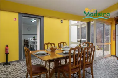 a dining room with a table and chairs at OurMadeira - Yellow House in Raposeira do Logarinho