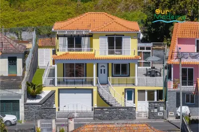 a yellow house with an orange roof at OurMadeira - Yellow House in Raposeira do Logarinho