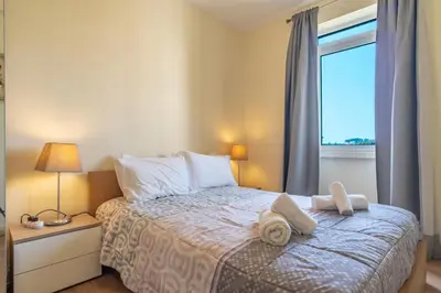 a kitchen with white cabinets and a large window at Elias Garcia T3 Apartment in Funchal