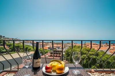 a table with a plate of fruit and a bottle of wine at Elias Garcia T3 Apartment in Funchal