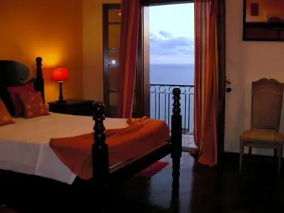 a bedroom with a bed with a view of the ocean at Villa São Paulo in Funchal