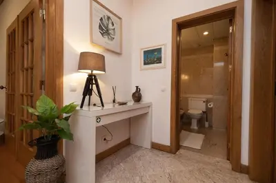 a bathroom with a toilet and a table with a lamp at Monumental Miramar Apartment by Rent-a-key in Funchal