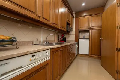 a large kitchen with wooden cabinets and a sink at Monumental Miramar Apartment by Rent-a-key in Funchal