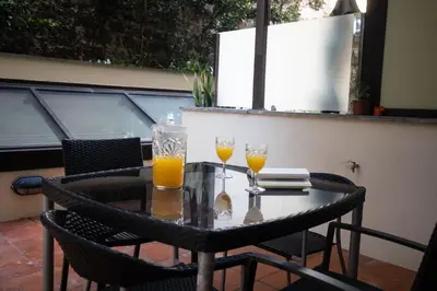 a table with two glasses of orange juice on a balcony at Monumental Miramar Apartment by Rent-a-key in Funchal