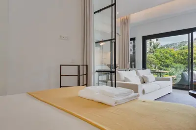 a white bedroom with a white couch and a bed at Acqua - Private Swimming Pool in Funchal