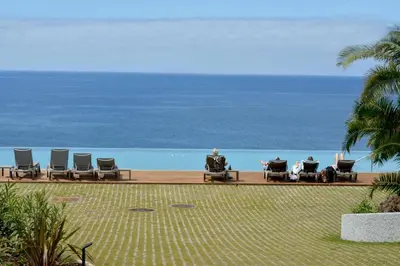 a group of people sitting in chairs on the beach at Acqua - Private Swimming Pool in Funchal