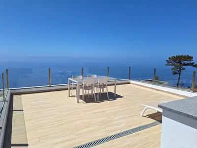a patio with a table and chairs on a roof at Quinta do Munot in Raposeira do Logarinho