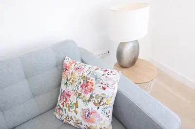 a gray couch with a pillow in a living room at Quinta do Munot in Raposeira do Logarinho