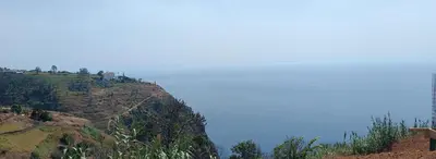 a view of a hill with the ocean on it at Quinta do Munot in Raposeira do Logarinho