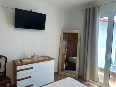 a bedroom with a mirror and a dresser and a bed at Gori House in Madalena do Mar