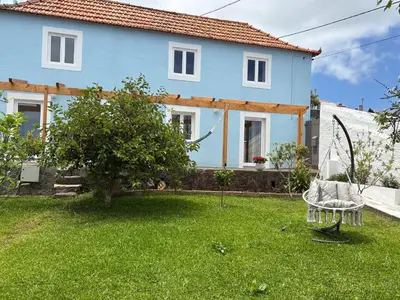 a blue house with a chair in the yard at The Blue Cottage in Gaula