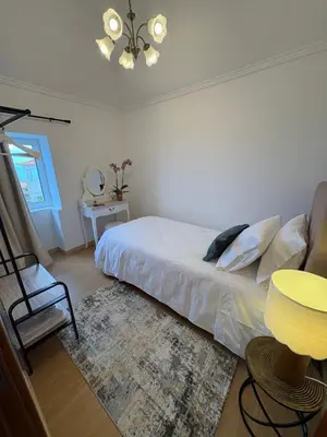 a bedroom with a bed and a chair and a table at The Blue Cottage in Gaula