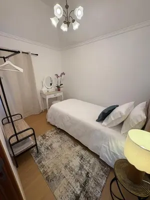 a bedroom with a bed and a chair and a table at The Blue Cottage in Gaula