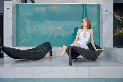a woman sitting on a ledge next to two large shoes at Saudade Residence - Ultra Luxury Futuristic Ocean Zen Retreat in Ribeira Brava
