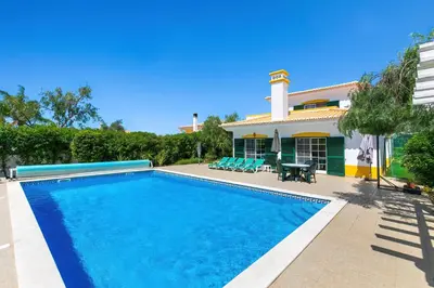a swimming pool in front of a house at Vila Rolas - Beautiful 5 bed villa with pool and aircon 3 min to Luz beach in Luz