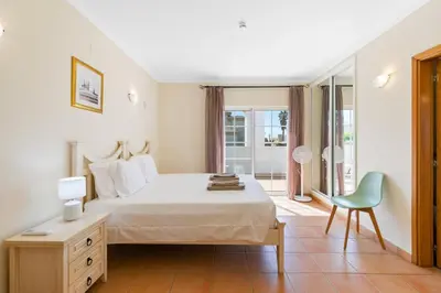 a bedroom with a bed and a desk and a chair at Vila Rolas - Beautiful 5 bed villa with pool and aircon 3 min to Luz beach in Luz