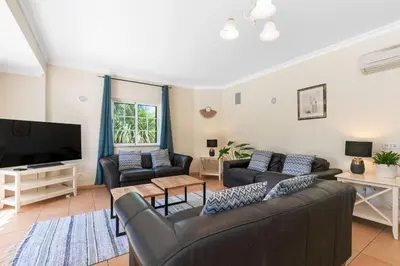 a living room with couches and a flat screen tv at Vila Rolas - Beautiful 5 bed villa with pool and aircon 3 min to Luz beach in Luz