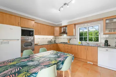 a kitchen with a table and chairs and a counter top at Vila Rolas - Beautiful 5 bed villa with pool and aircon 3 min to Luz beach in Luz
