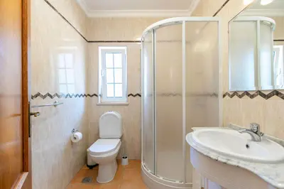 a bathroom with a toilet and a sink and a shower at Vila Rolas - Beautiful 5 bed villa with pool and aircon 3 min to Luz beach in Luz