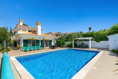 a villa with a swimming pool in front of a house at Vila Rolas - Beautiful 5 bed villa with pool and aircon 3 min to Luz beach in Luz