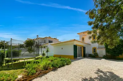 a house with a swing in a yard at Vila Rolas - Beautiful 5 bed villa with pool and aircon 3 min to Luz beach in Luz