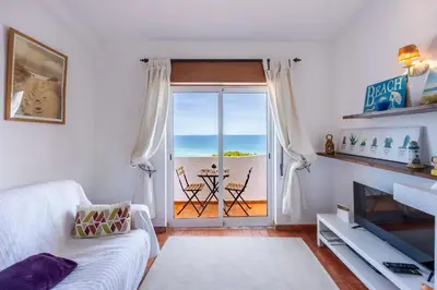 a balcony with two chairs and a view of the ocean at incredible view- T1 Salema in Salema