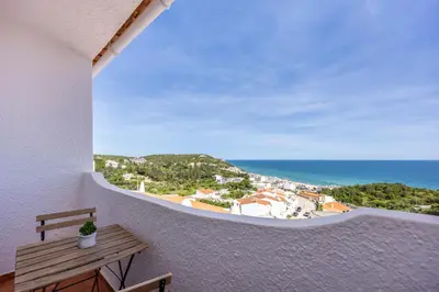 a bedroom with a white bed and a wooden floor at incredible view- T1 Salema in Salema