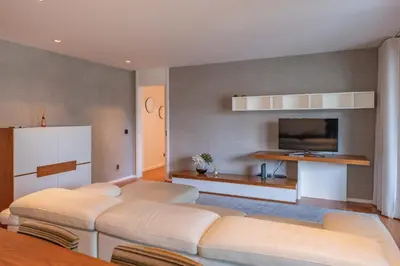 a living room with two beds and a flat screen tv at FLH Funchal Elegant Apartment with Pool & Balcony in Funchal