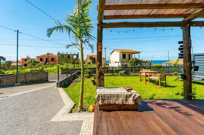 a pavilion with a table and a palm tree at Fajã Lodges - House Ash in São Vicente