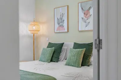 a bedroom with a bed with green and white pillows at Green Living-Funchal in Funchal