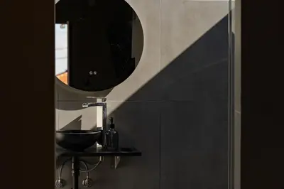 a bathroom with a sink and a mirror on a wall at Fajã Lodges - Studio Ash in São Vicente