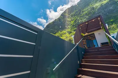 a staircase leading up to a building with a mountain at Fajã Lodges - Studio Ash in São Vicente