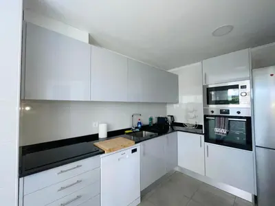 a white kitchen with white cabinets and appliances at Piornais Apartment by Susys Holidays in Funchal
