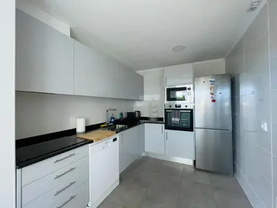 a kitchen with white cabinets and a stainless steel refrigerator at Piornais Apartment by Susys Holidays in Funchal