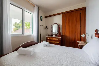 a bedroom with a bed and a mirror and a window at Miradouro House By Sam Houses in Ponta do Sol