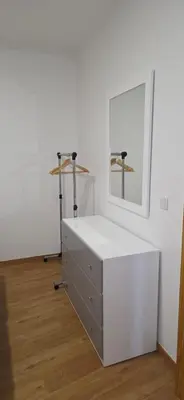 a white room with a dresser and a mirror at Pôr do Sol II in Porto Moniz