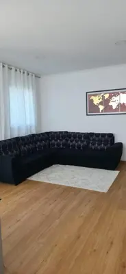 a black couch in a living room with a white rug at Pôr do Sol II in Porto Moniz