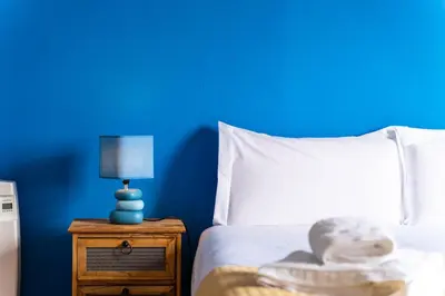 a blue bedroom with a white bed and a blue wall at GuestReady – Rustic Charm in Peaceful Madeira in Porto da Cruz