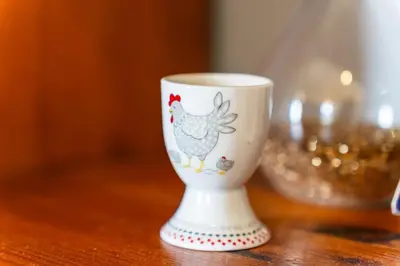 a white cup with a chicken on it on a table at GuestReady – Rustic Charm in Peaceful Madeira in Porto da Cruz