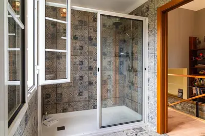 a shower with a glass door in a bathroom at GuestReady – Rustic Charm in Peaceful Madeira in Porto da Cruz