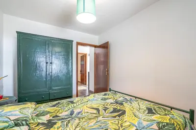 a bedroom with a bed and a green cabinet at Casa de Campo Serrão in Calheta