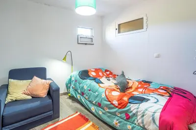 a bedroom with a bed and a couch and a chair at Casa de Campo Serrão in Calheta
