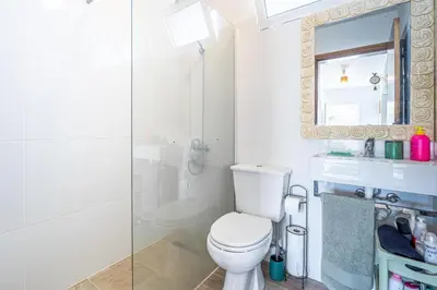 a white bathroom with a toilet and a shower at Casa de Campo Serrão in Calheta