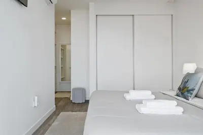 a white bedroom with two beds with white sheets at Villa Vellure by Homie in Funchal