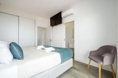 a bedroom with a bed and a chair at Villa Vellure by Homie in Funchal